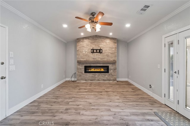 unfurnished living room with ceiling fan, vaulted ceiling, a fireplace, light hardwood / wood-style floors, and ornamental molding