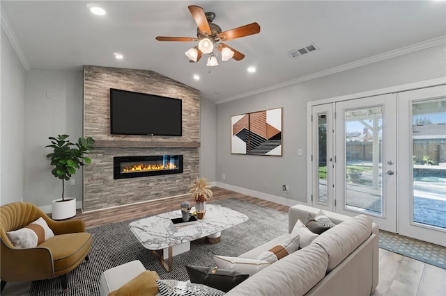 living room featuring lofted ceiling, a fireplace, ornamental molding, and light hardwood / wood-style floors