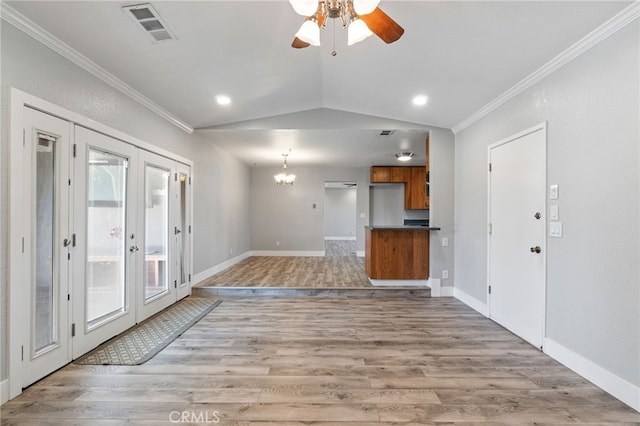 unfurnished living room featuring wood-type flooring, french doors, and vaulted ceiling