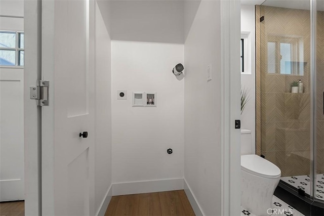 bathroom featuring toilet, a shower with shower door, and hardwood / wood-style flooring