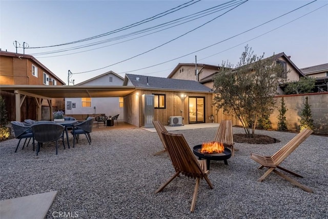 back house at dusk with a fire pit and a patio