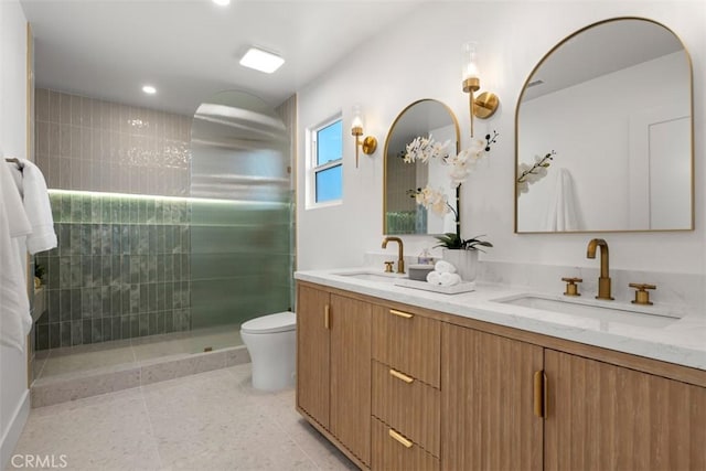 bathroom with toilet, a tile shower, tile patterned floors, and vanity