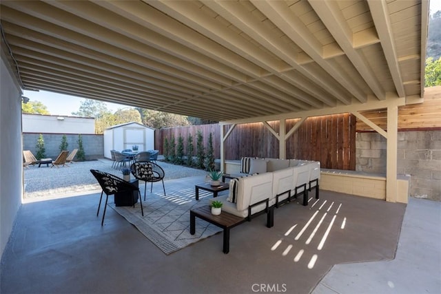 view of patio with a storage shed and an outdoor living space