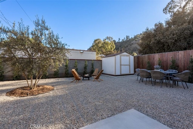 view of yard with a fire pit and a storage shed