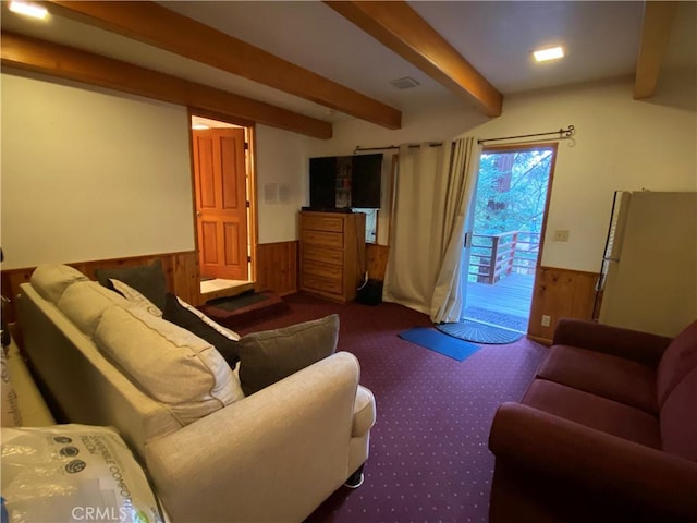 living room featuring beam ceiling and wooden walls