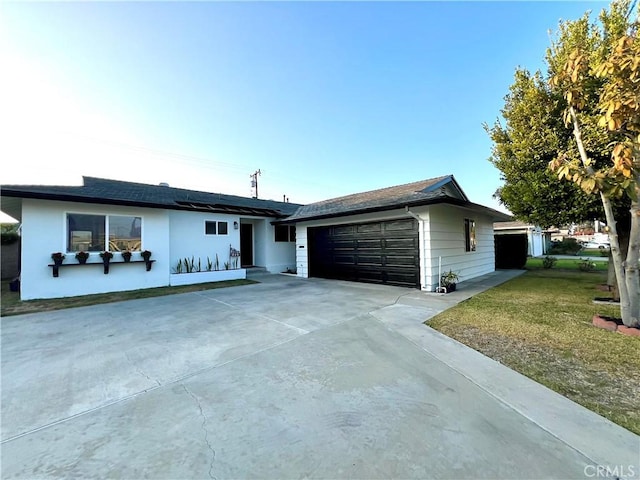 ranch-style home featuring a garage and a front lawn