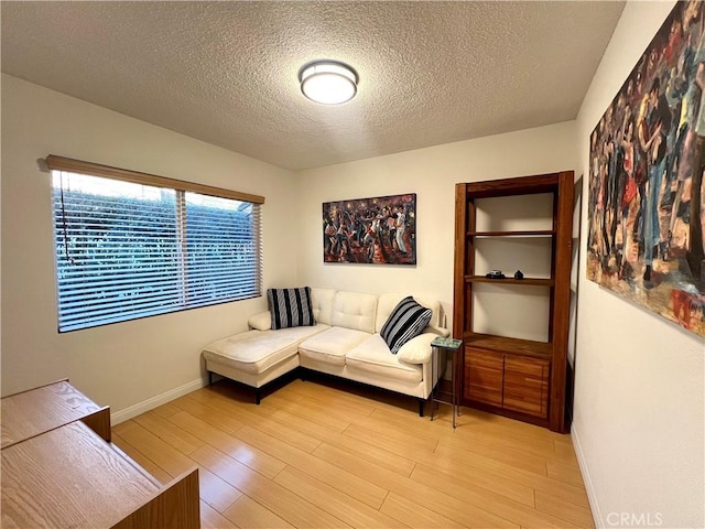 living room with light wood-type flooring and a textured ceiling