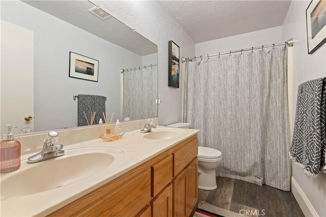 full bathroom featuring toilet, vanity, wood-type flooring, and shower / tub combo