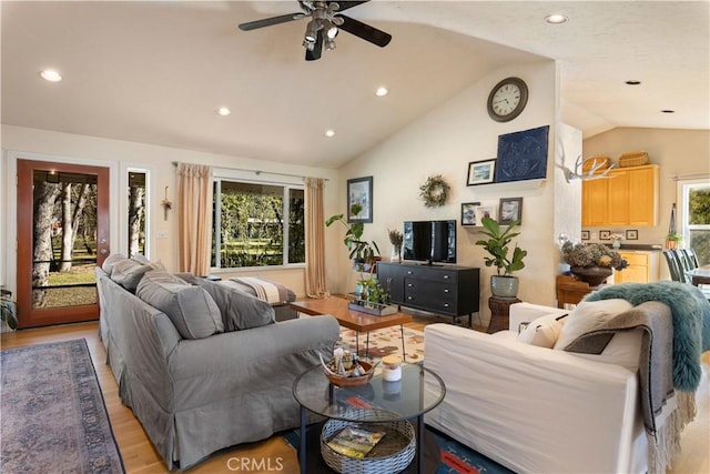 living room with light wood-type flooring, vaulted ceiling, and ceiling fan