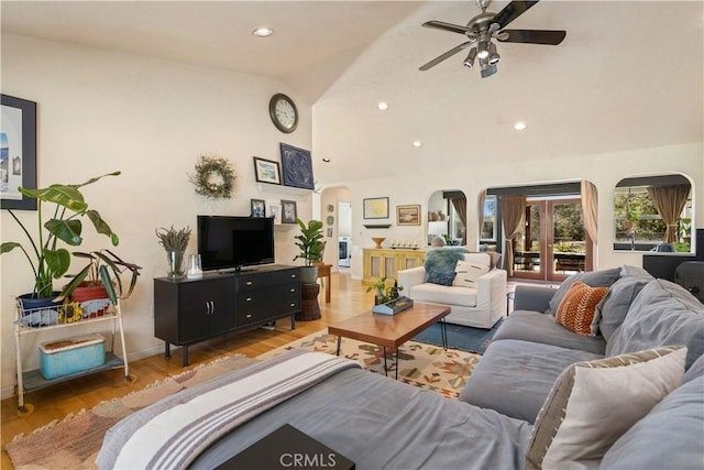 living room with ceiling fan, hardwood / wood-style floors, and vaulted ceiling