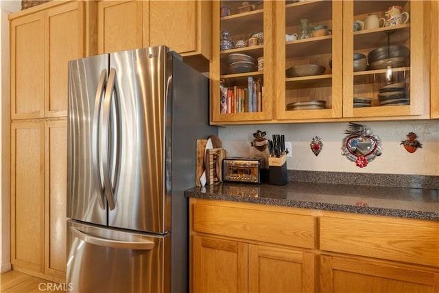 kitchen with light hardwood / wood-style floors, stainless steel fridge, and tasteful backsplash