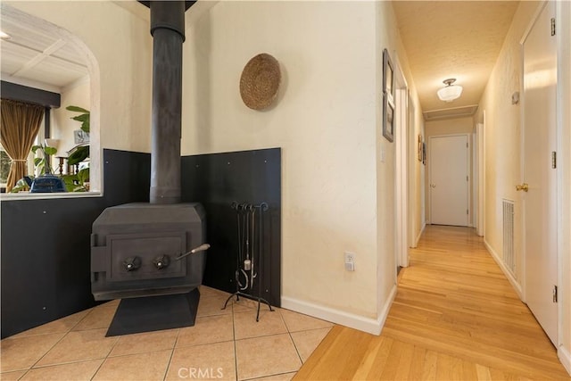 corridor with coffered ceiling, a textured ceiling, and light hardwood / wood-style flooring