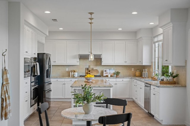 kitchen featuring sink, stainless steel appliances, white cabinets, a center island, and hanging light fixtures