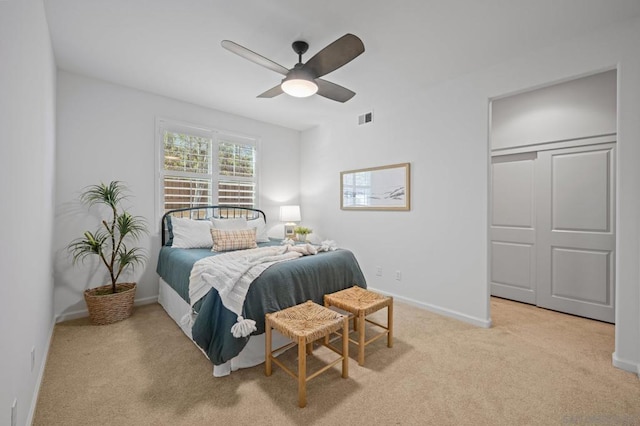 carpeted bedroom featuring ceiling fan and a closet