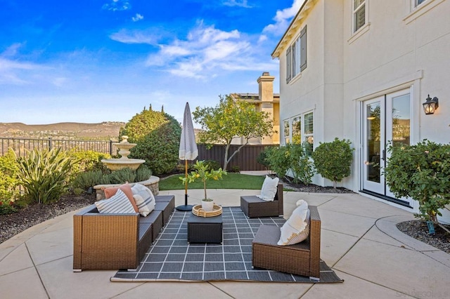 view of patio featuring french doors, outdoor lounge area, and a mountain view