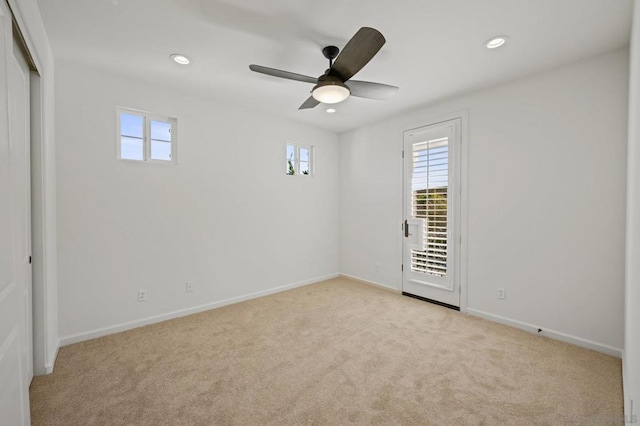 carpeted spare room featuring ceiling fan