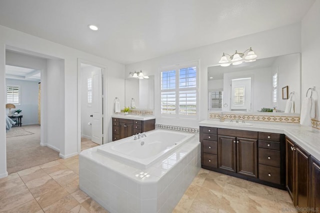 bathroom featuring tiled bath, tasteful backsplash, and vanity