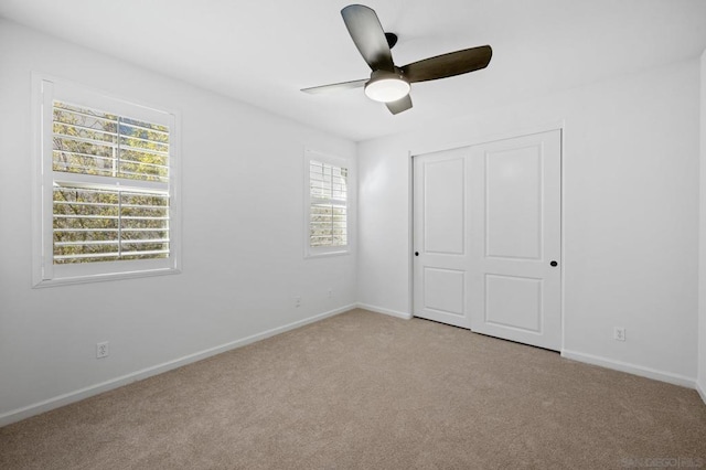 unfurnished bedroom featuring ceiling fan, a closet, and light carpet