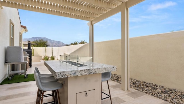 view of patio with a mountain view, a pergola, and an outdoor bar