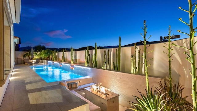 pool at dusk with a fire pit