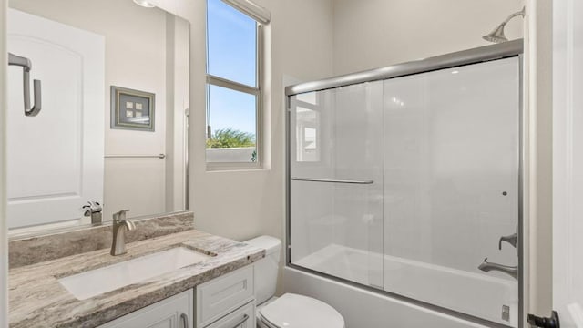 full bathroom featuring bath / shower combo with glass door, vanity, and toilet