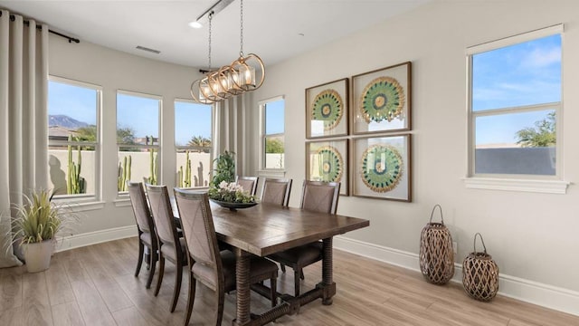 dining area featuring a mountain view, an inviting chandelier, and light hardwood / wood-style floors