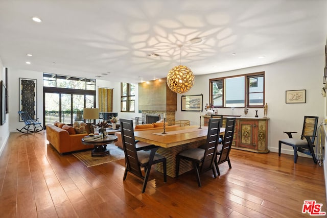 dining room with hardwood / wood-style flooring and a fireplace