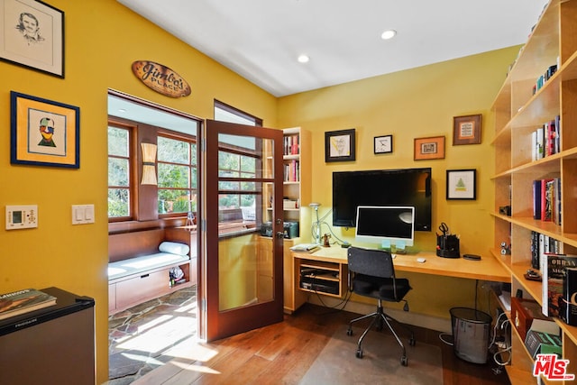 office with hardwood / wood-style flooring and french doors