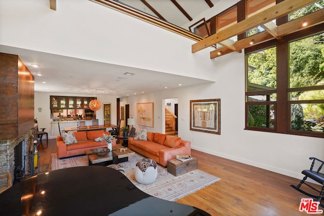 living room featuring a towering ceiling and light hardwood / wood-style floors