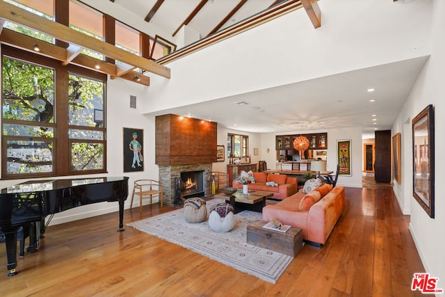 living room with a high ceiling, wood-type flooring, and plenty of natural light