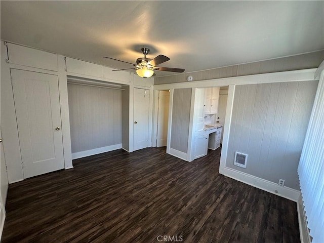 unfurnished bedroom with ceiling fan, a closet, and dark hardwood / wood-style floors