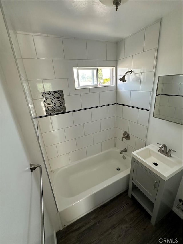 bathroom with tiled shower / bath, vanity, and hardwood / wood-style floors