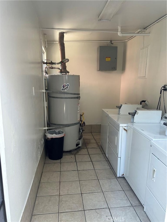 washroom with light tile patterned flooring, secured water heater, and washing machine and clothes dryer