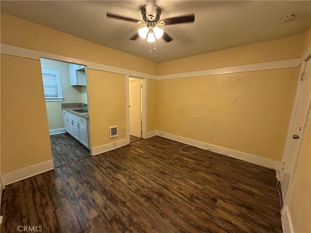 interior space with dark wood-type flooring, sink, and ceiling fan