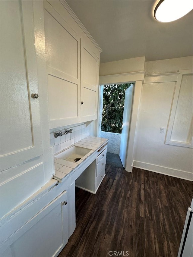 kitchen with backsplash, dark wood-type flooring, sink, and white cabinetry