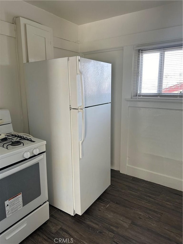 kitchen with dark hardwood / wood-style flooring and white appliances