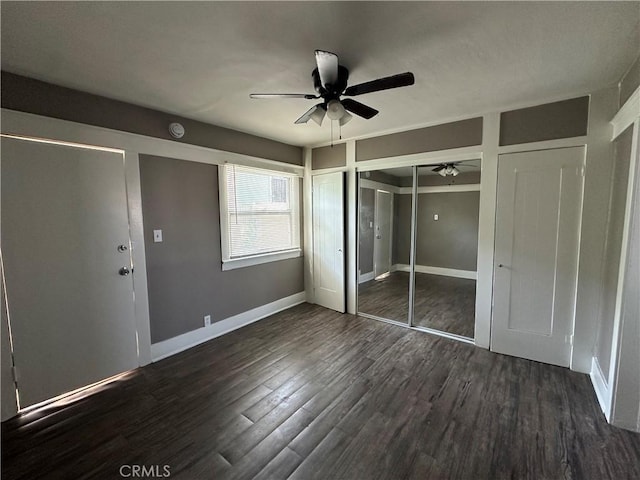 unfurnished bedroom with ceiling fan and dark wood-type flooring