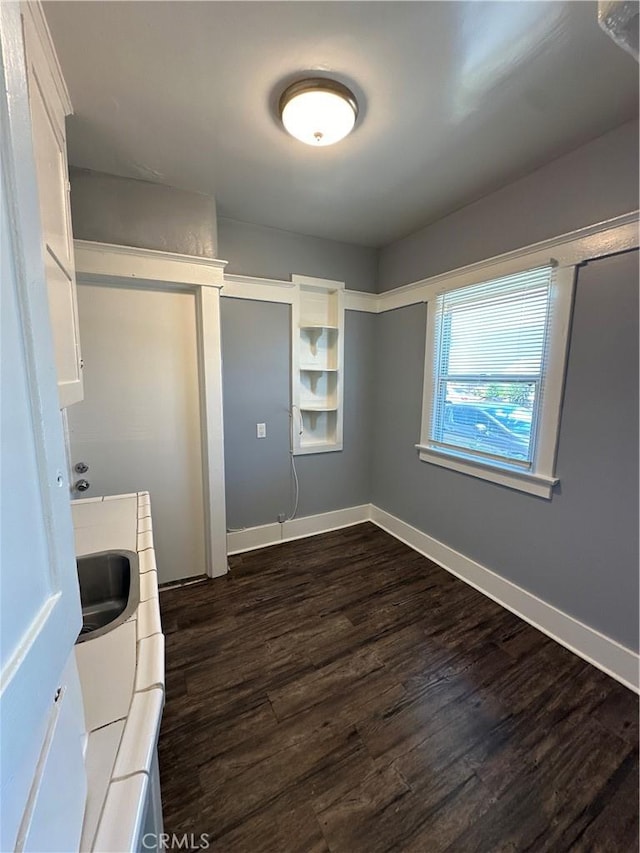 laundry area featuring washing machine and dryer, dark hardwood / wood-style flooring, and sink