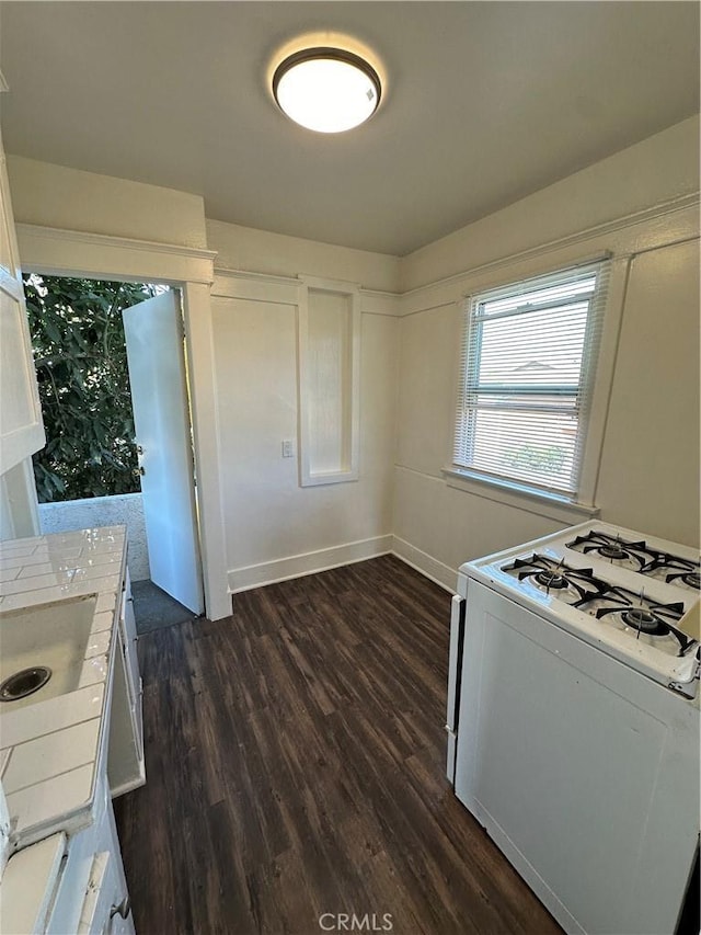 kitchen featuring white cabinets, white gas range, and dark hardwood / wood-style flooring