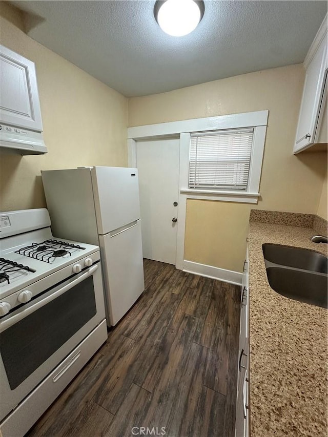 kitchen featuring sink, white appliances, white cabinets, and a textured ceiling