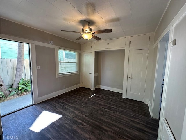 unfurnished bedroom with ceiling fan and dark hardwood / wood-style flooring