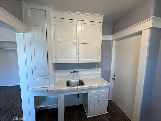 kitchen with sink, white cabinetry, dark hardwood / wood-style floors, and tile counters