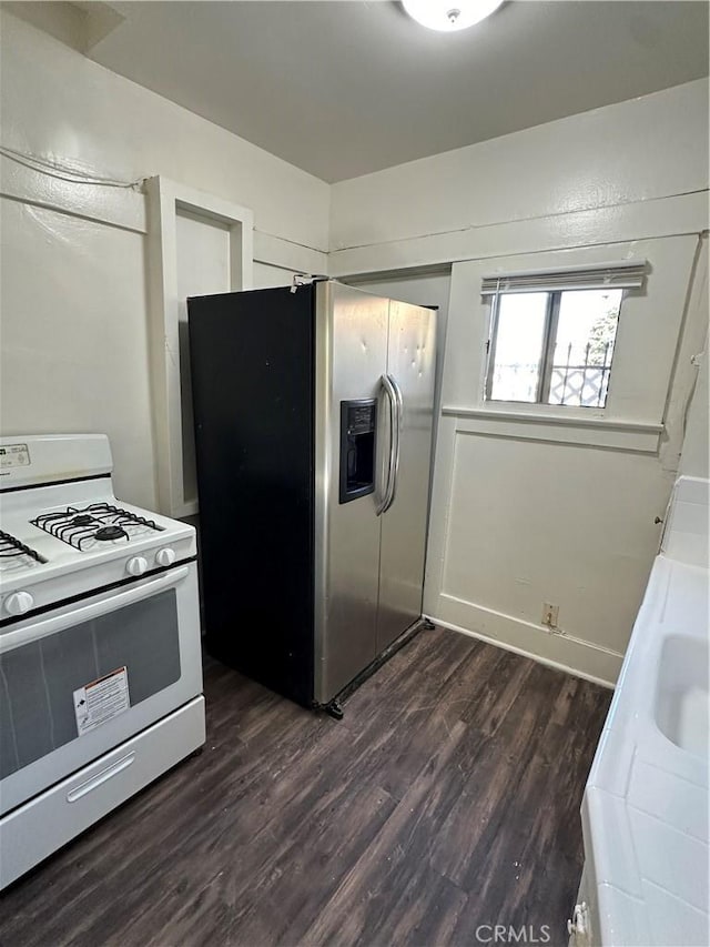 kitchen featuring dark wood-type flooring, stainless steel refrigerator with ice dispenser, and white range with gas stovetop