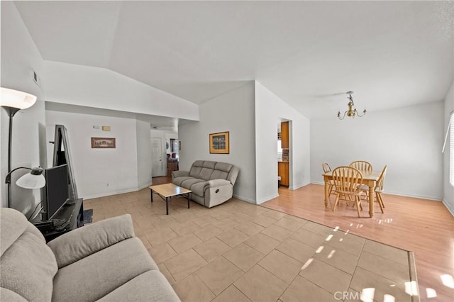 living room with a chandelier and lofted ceiling