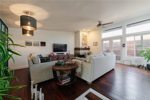 living room featuring ceiling fan and dark wood-type flooring