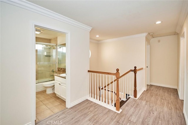 hallway featuring light wood-type flooring and ornamental molding