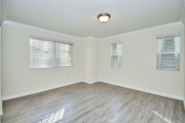 empty room with light wood-type flooring and ornamental molding