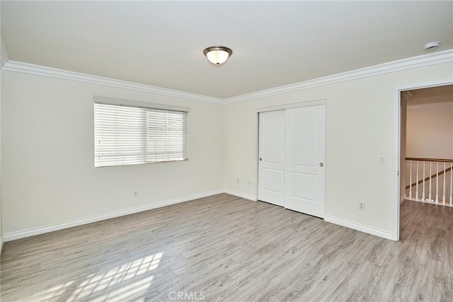 unfurnished bedroom with a closet, light hardwood / wood-style flooring, and ornamental molding