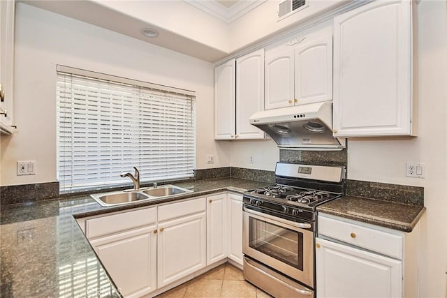 kitchen with sink, gas range, ornamental molding, light tile patterned flooring, and white cabinetry