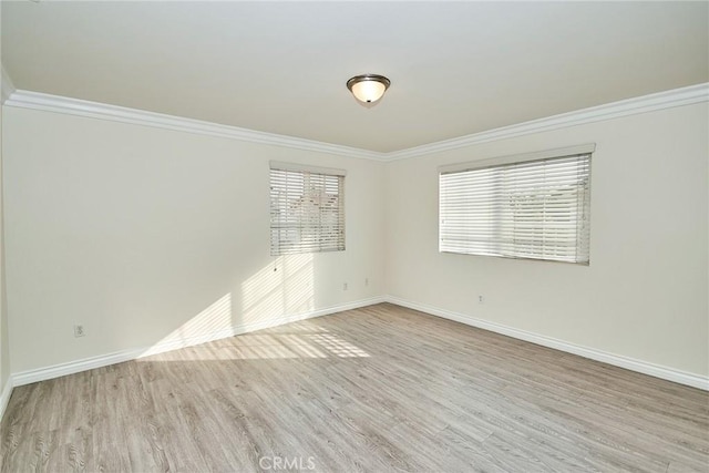 spare room featuring ornamental molding and light hardwood / wood-style flooring